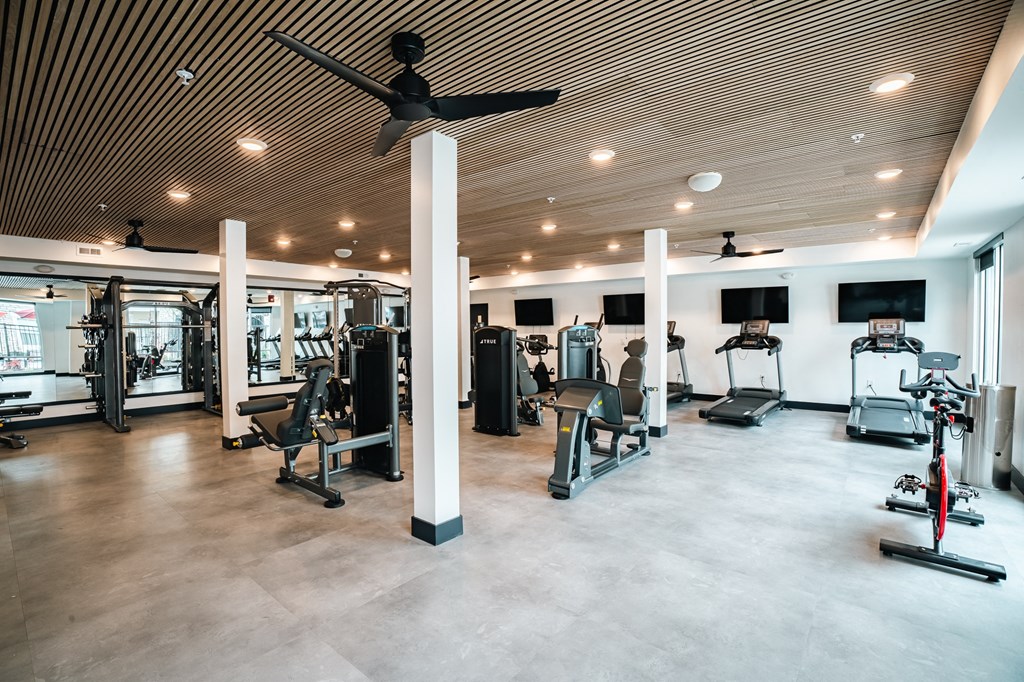 24 hour fitness center with treadmills, weight benches, and