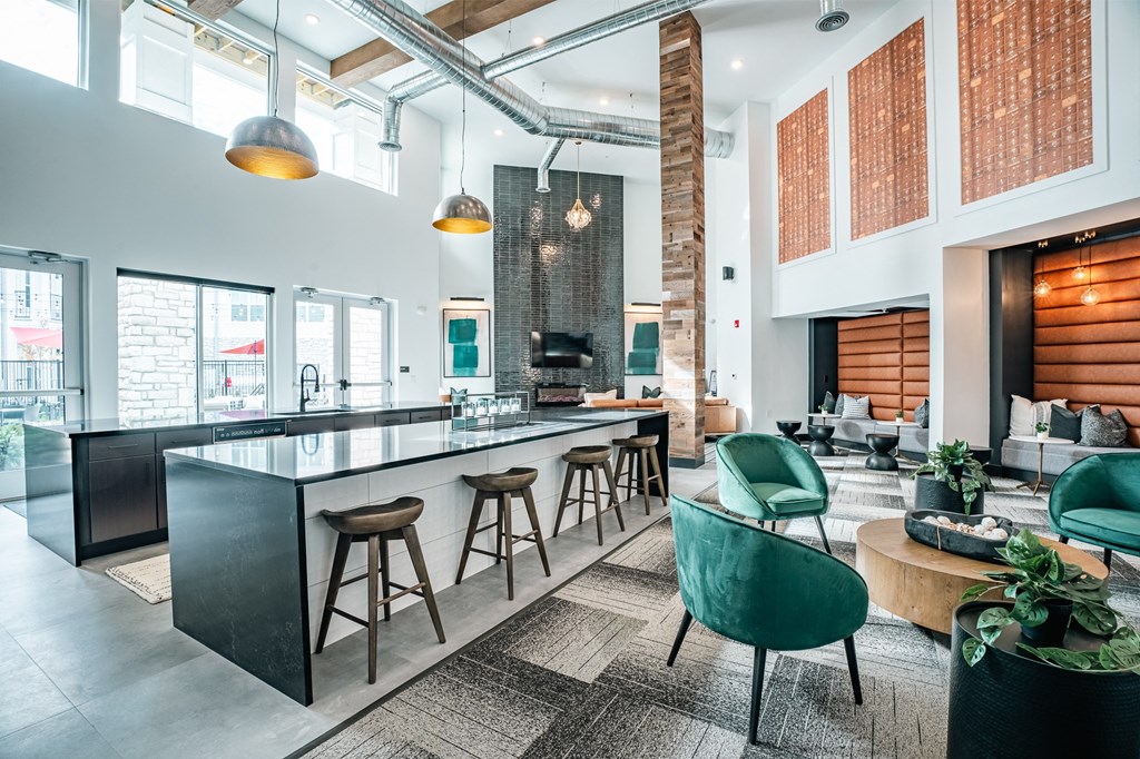 resident clubhouse with green chairs, bar space, and vaulted ceilings