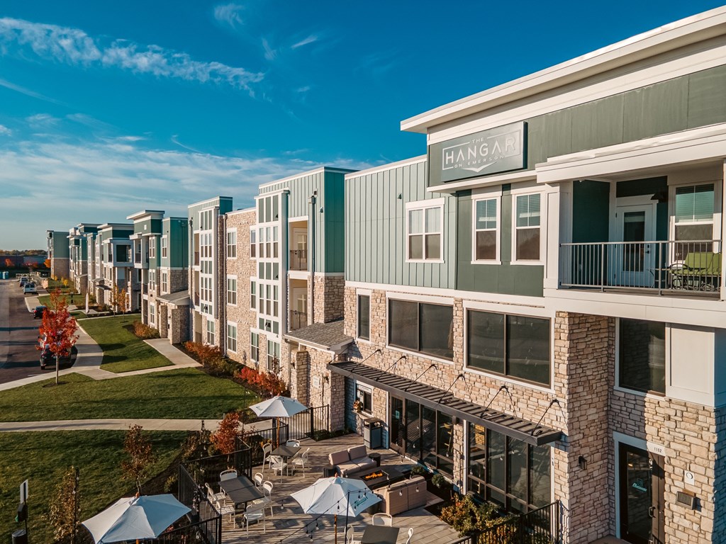 a row of townhouses with tables and umbrellas outside of a building