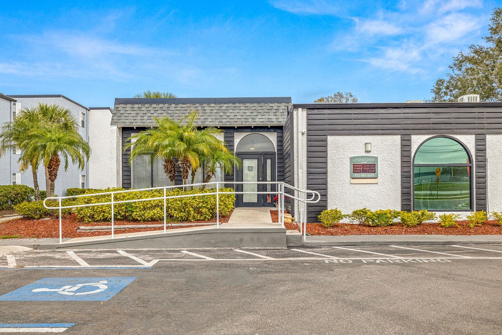 a building with palm trees and a parking lot