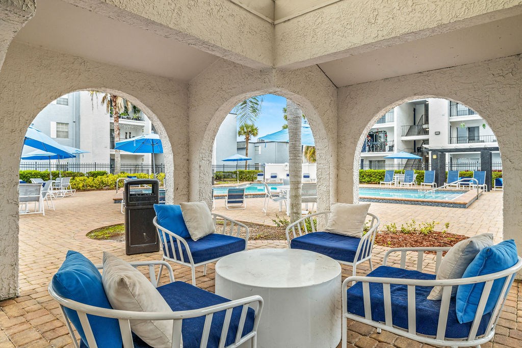 a patio with chairs and tables and a pool