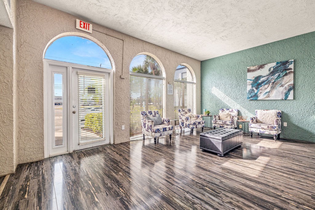 a living room with chairs and a table and a exit sign