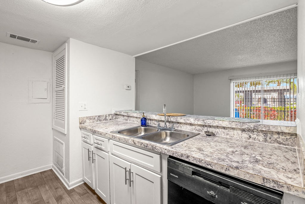 a kitchen with white cabinets and granite counter tops and a sink