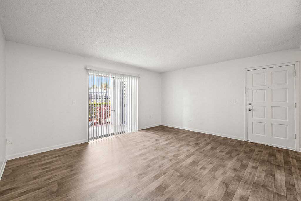 an empty living room with a door to a patio