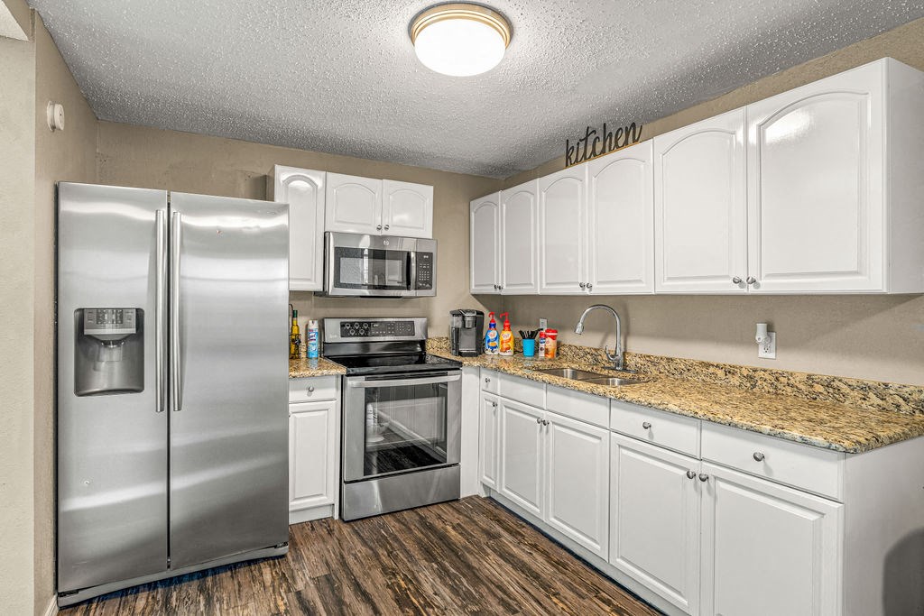 a kitchen with stainless steel appliances and white cabinets