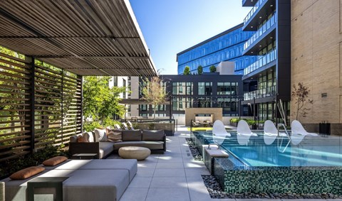 A modern outdoor seating area with a pool and loungers.