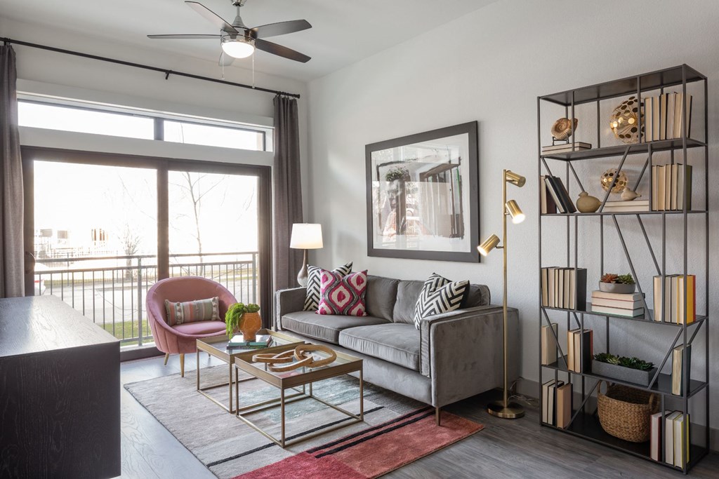 a living room with a gray couch and a sliding glass door