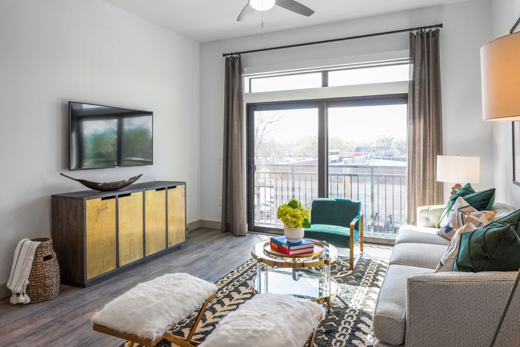 a living room with a couch and a tv and a balcony