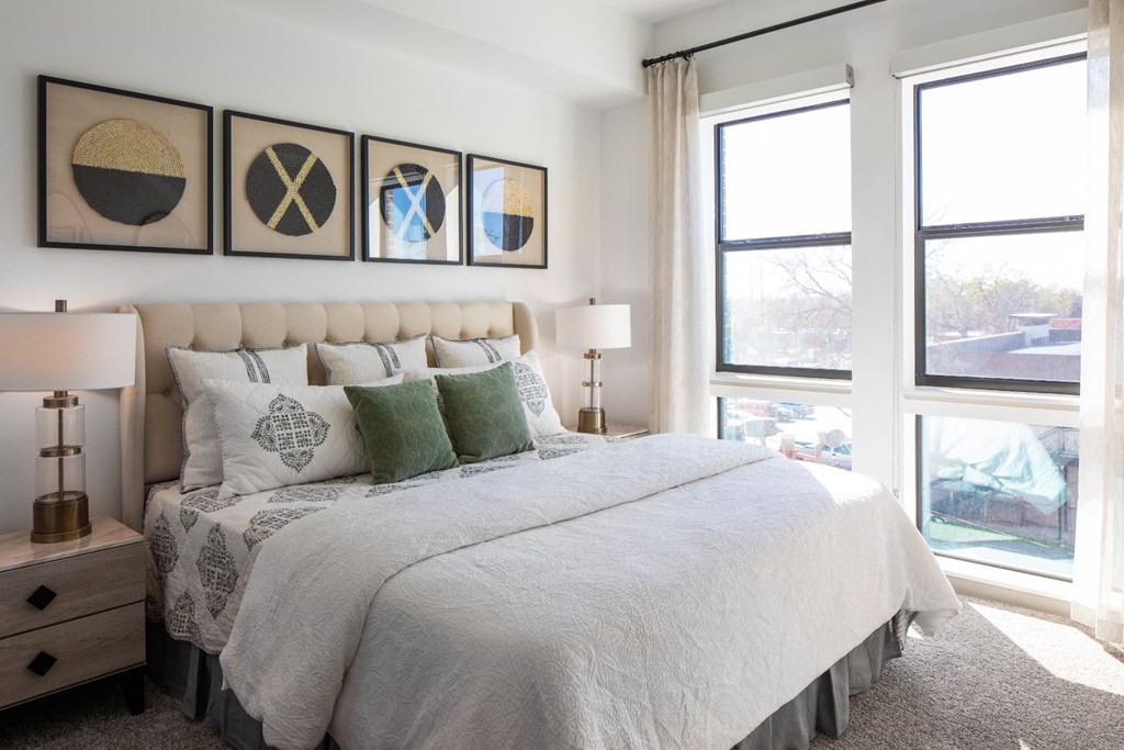 a bedroom with a bed and three windows