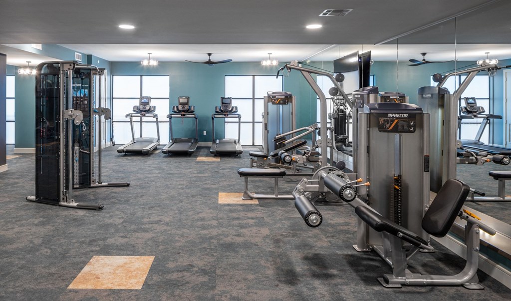 a gym with weights and cardio equipment in a building