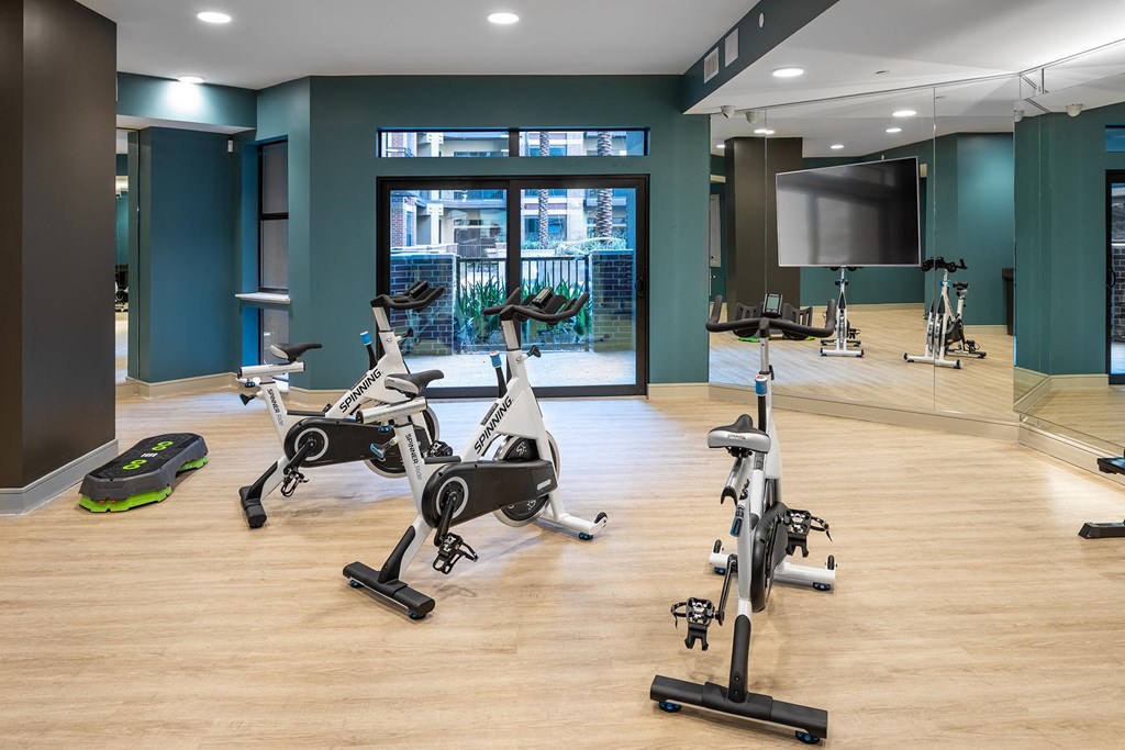 a gym with exercise bikes and a television