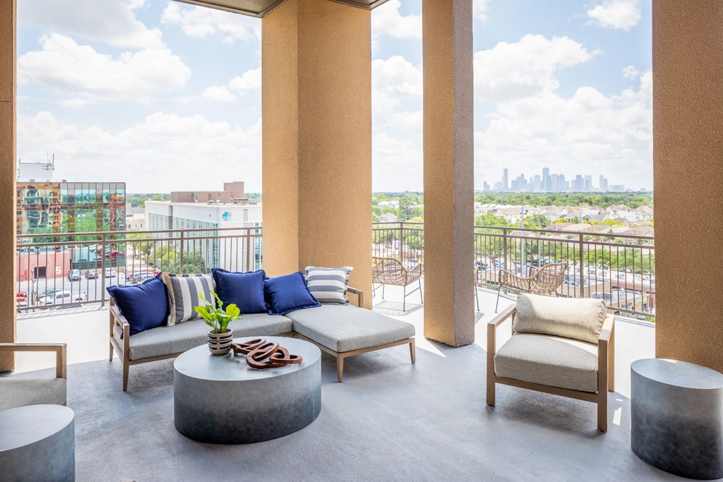 a balcony with couches and chairs and a view of the city