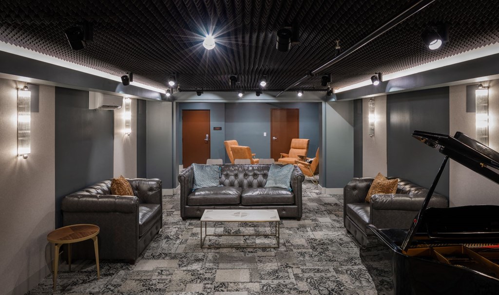 a living room with couches and a piano