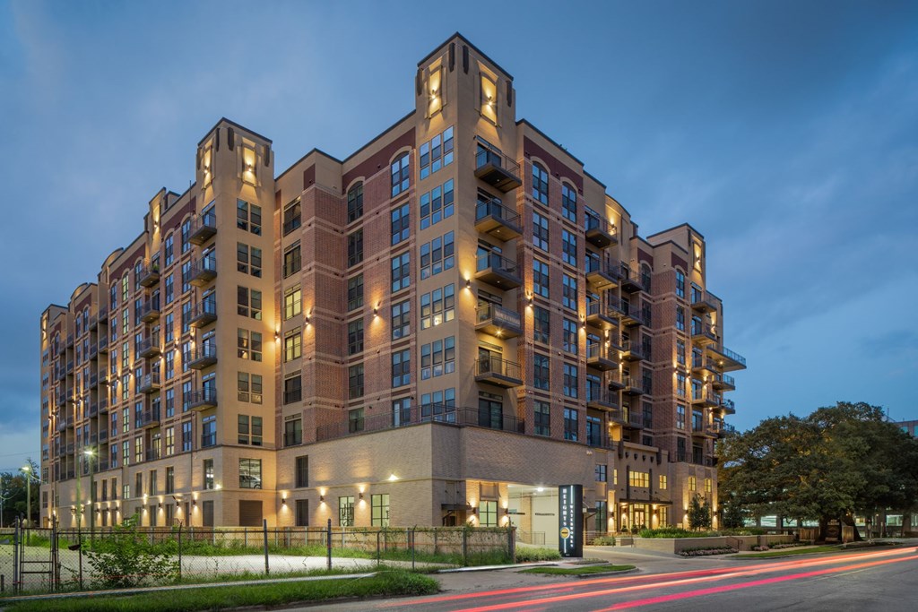 a rendering of a large apartment building at dusk