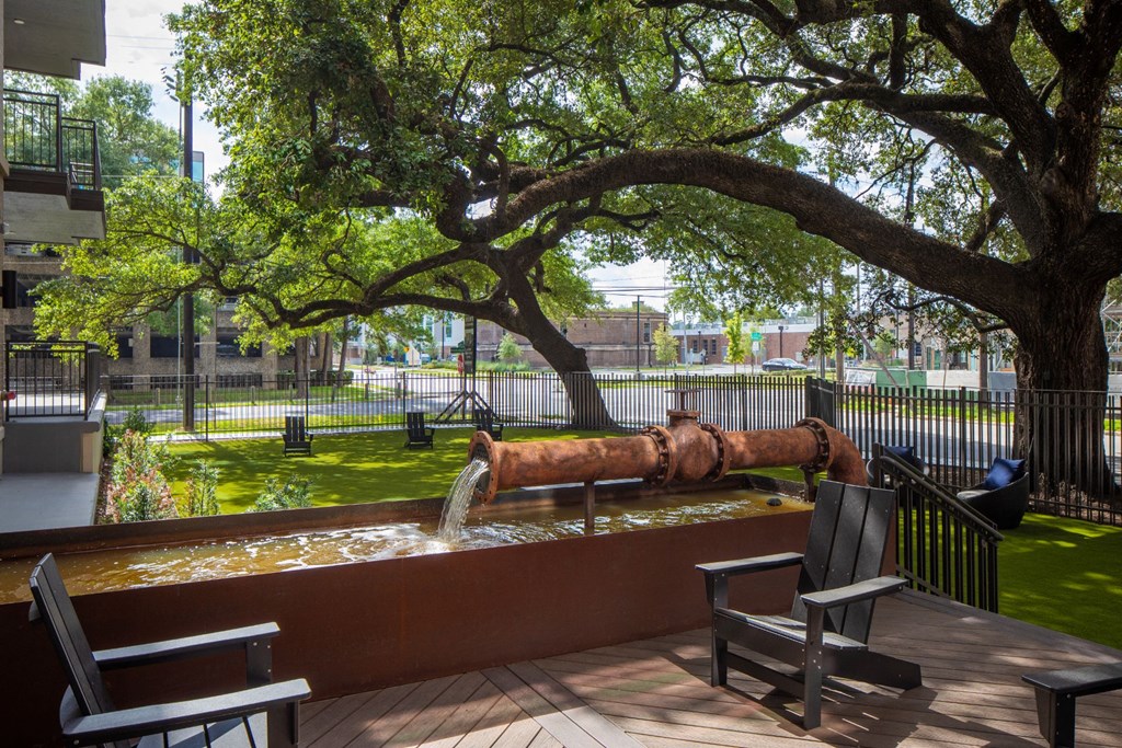 a fountain in a park with benches and trees