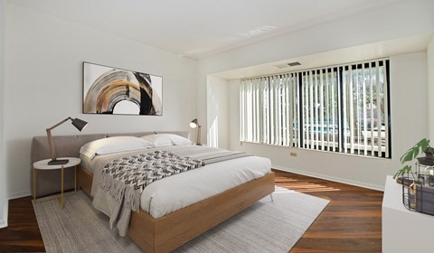 A bedroom with a large bed and a painting on the wall.