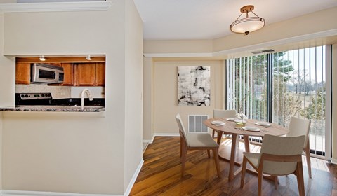 A kitchen with a dining table and chairs.
