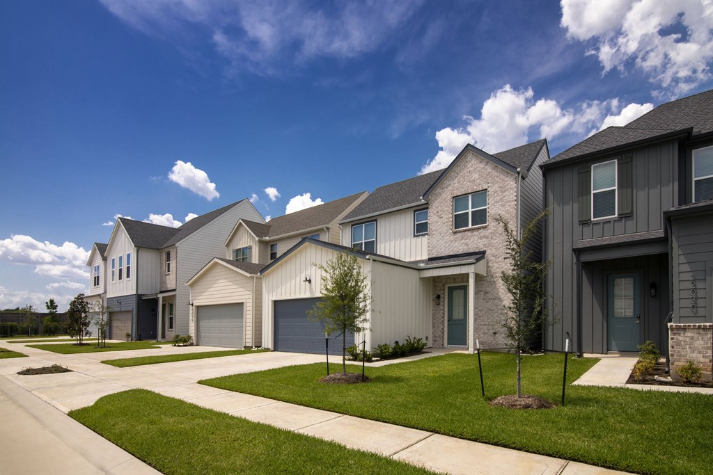 A row of modern houses with garages and driveways.