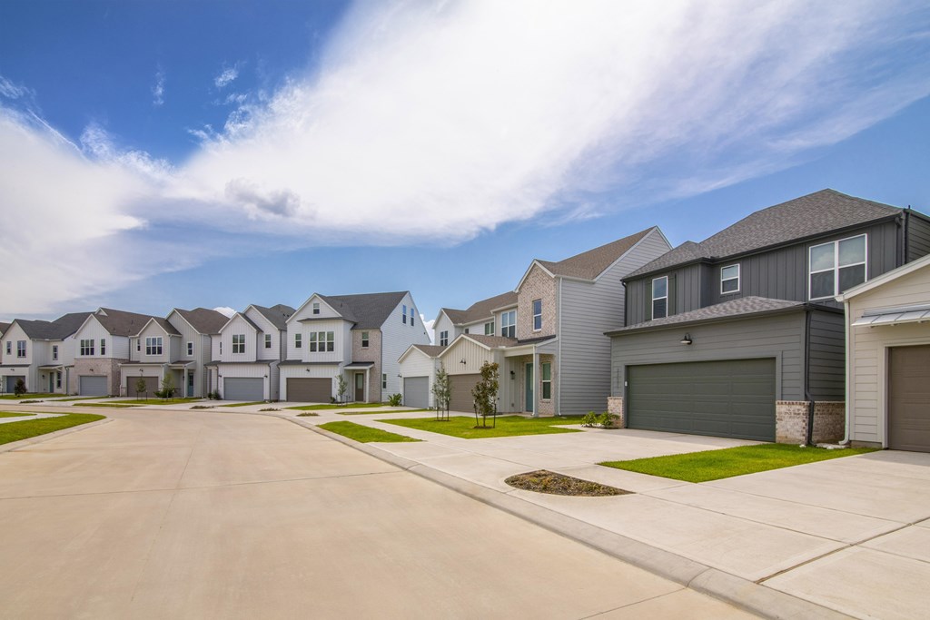 A row of houses with driveways in front.