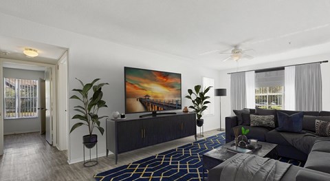 A living room with a large painting on the wall and a dark grey sofa.