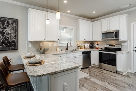 A kitchen with white cabinets and a granite countertop.