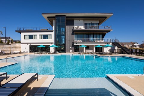 A modern house with a pool in front.