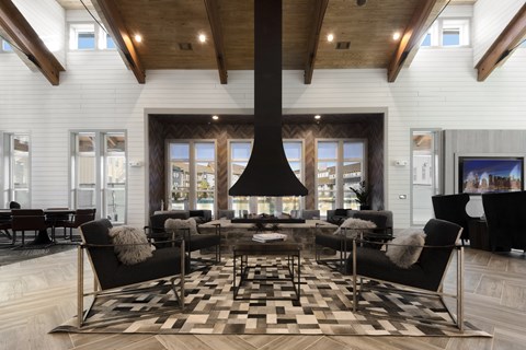 A modern living room with a black and white checkered rug and a large black fireplace.