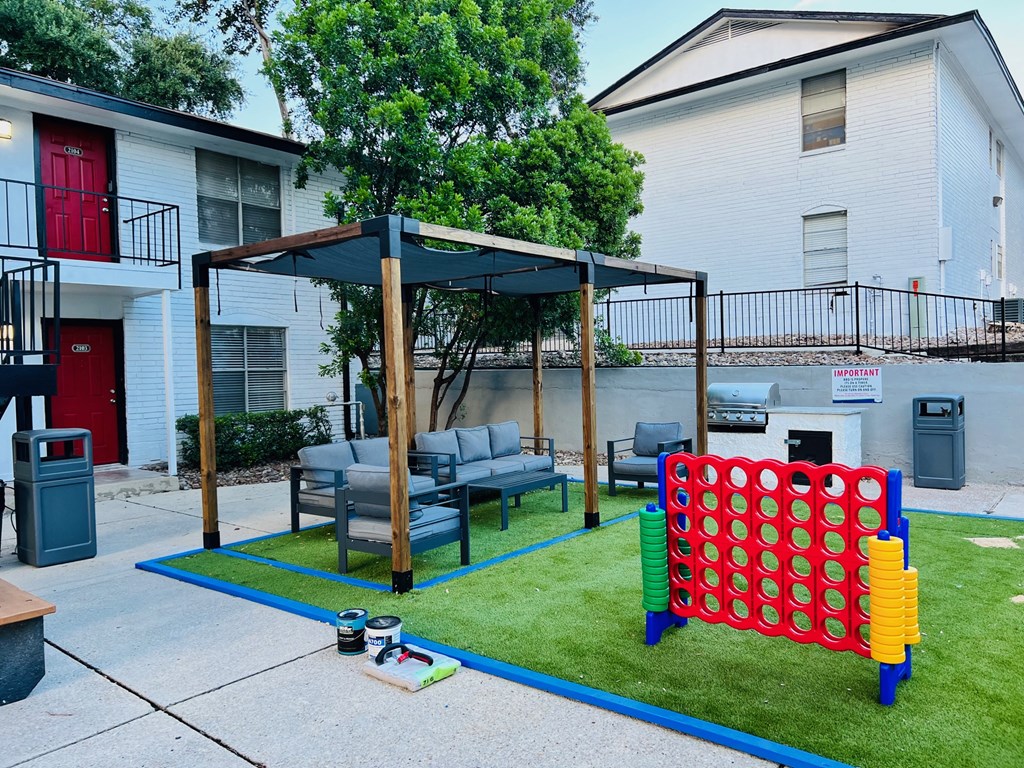 our yard has a play area with a swing set and a game