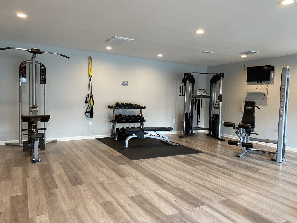 a home gym with a wood floor and white walls