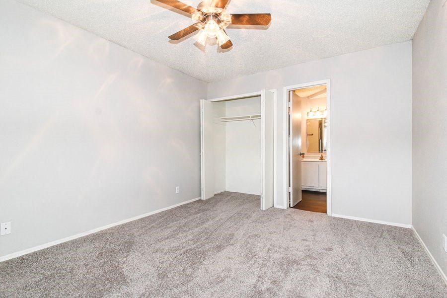 an empty living room with a ceiling fan