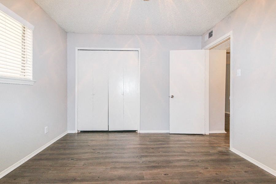 an empty living room with white walls and wood floors