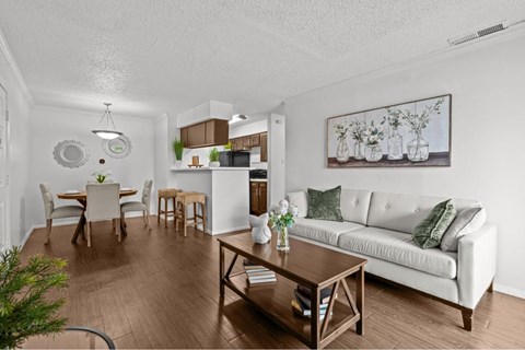 A living room with a white couch and a wooden coffee table.