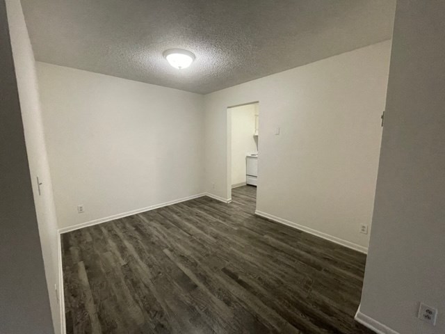 an empty living room with wood flooring and white walls