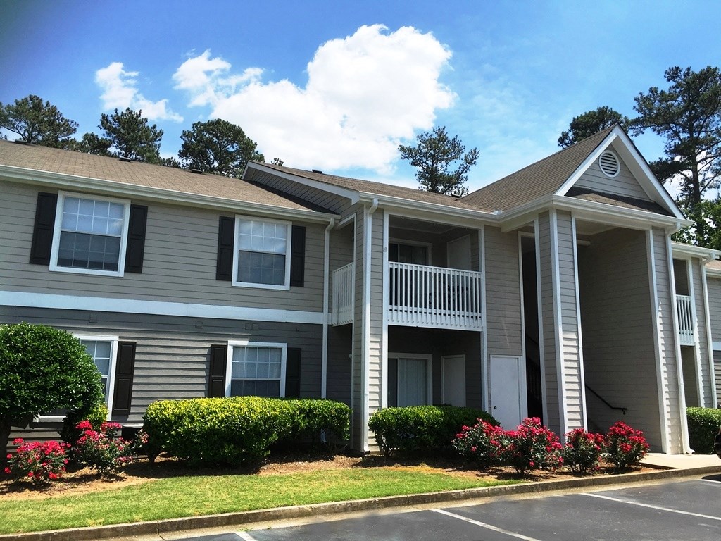 a house with a porch and a parking lot in front of it