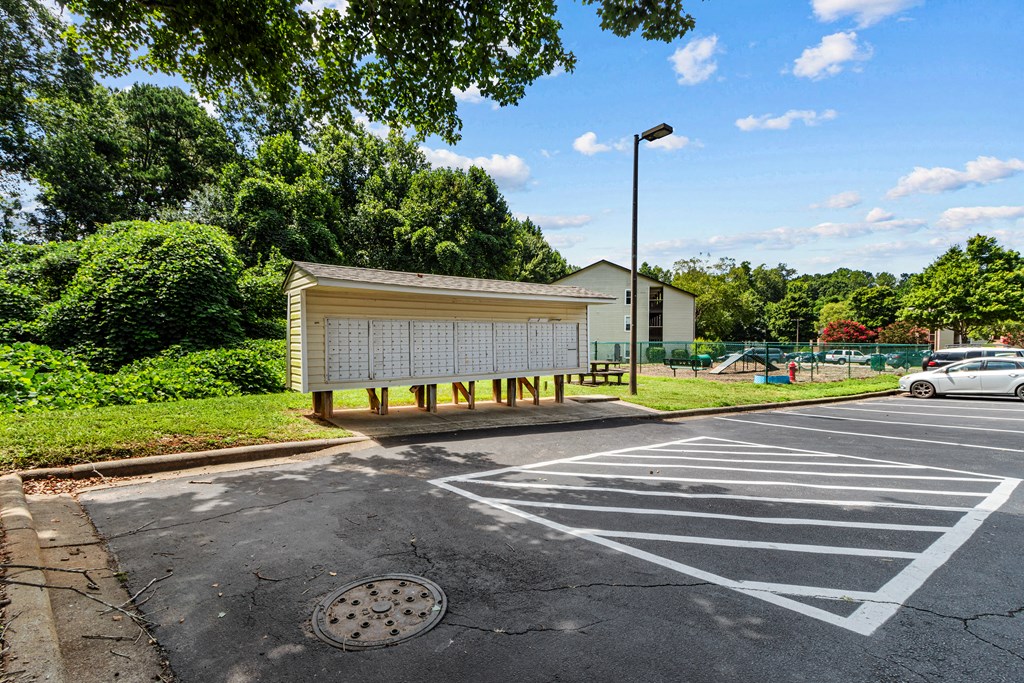 a parking lot with a bus stop in front of a park