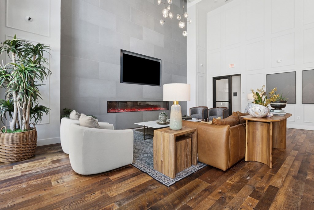 A modern living room with a fireplace and a flat screen TV mounted on the wall.