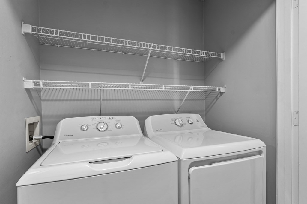 the laundry room of a home with two washes and a dryer