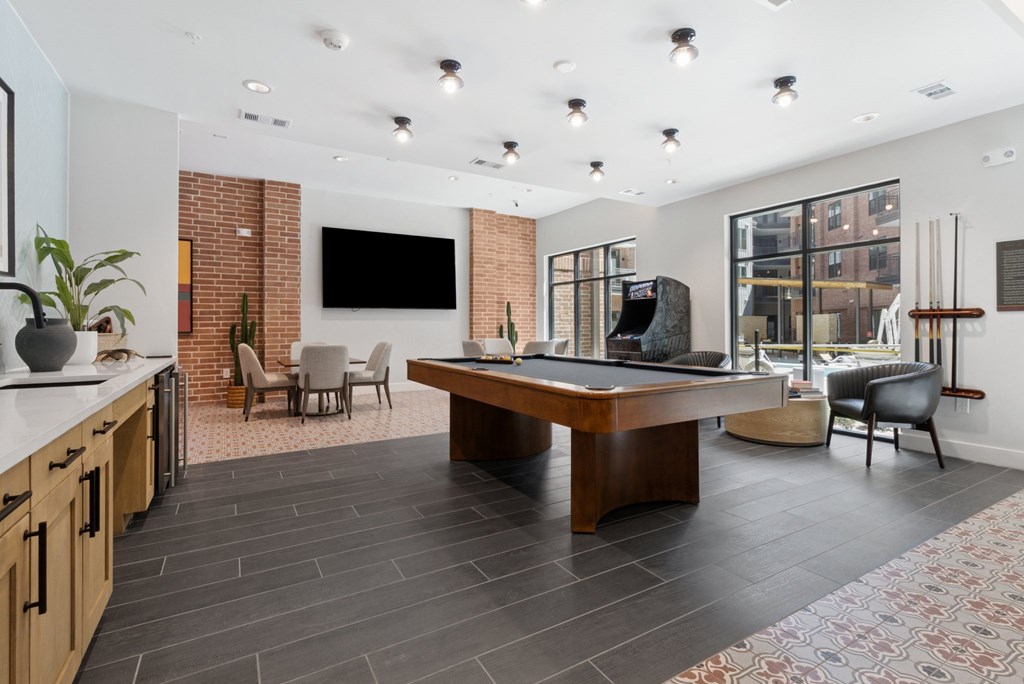 A modern living room with a pool table and a television.