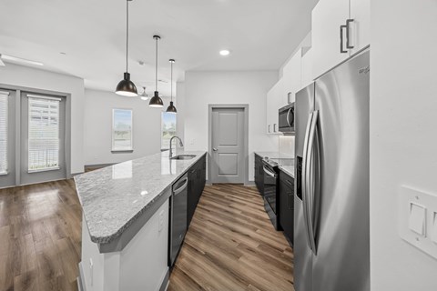 A modern kitchen with a refrigerator on the right side.
