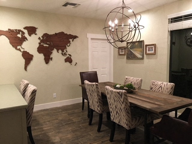 a dining room with a table and chairs and a world map on the wall