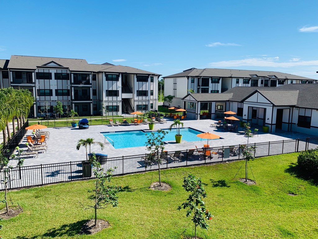 an aerial view of a swimming pool with apartments in the background