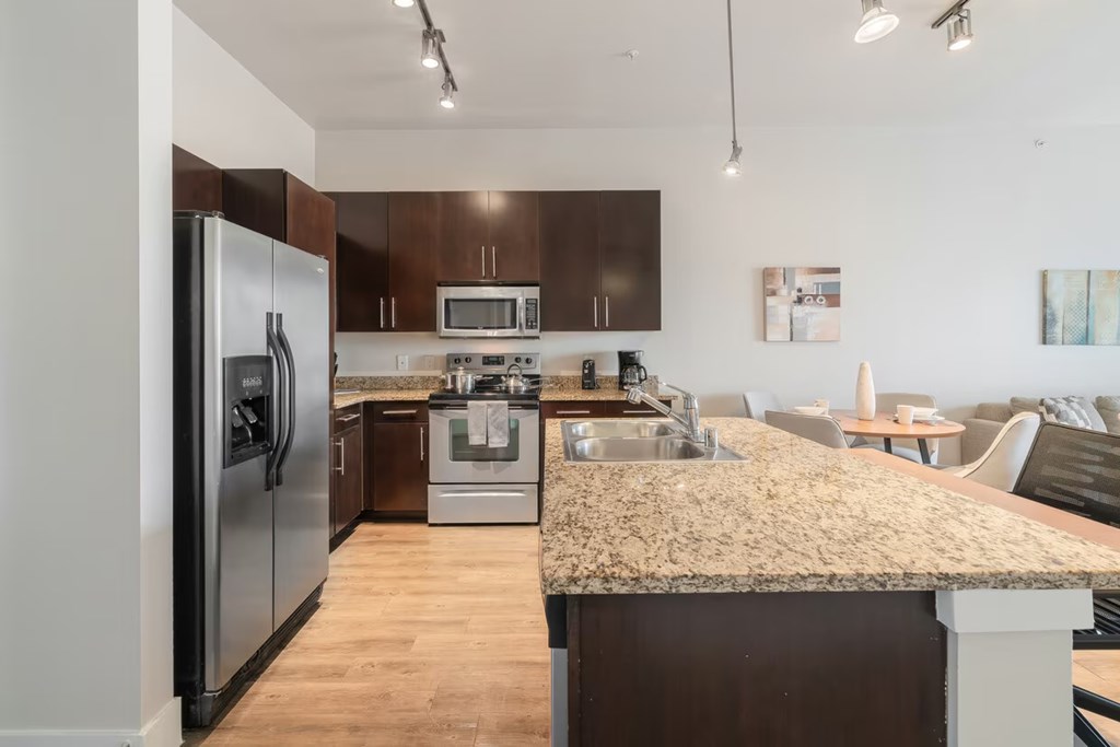 A kitchen with a granite countertop and stainless steel appliances.