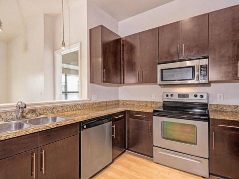 A kitchen with brown cabinets and stainless steel appliances.