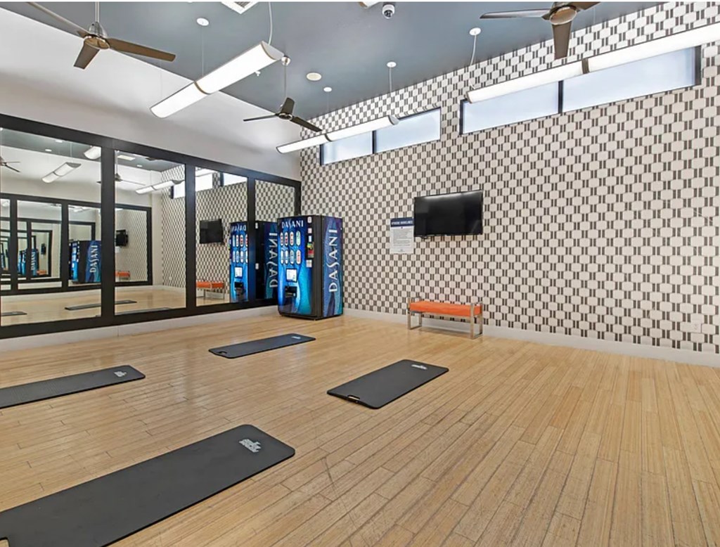 A room with wooden floors and mirrors on the wall.