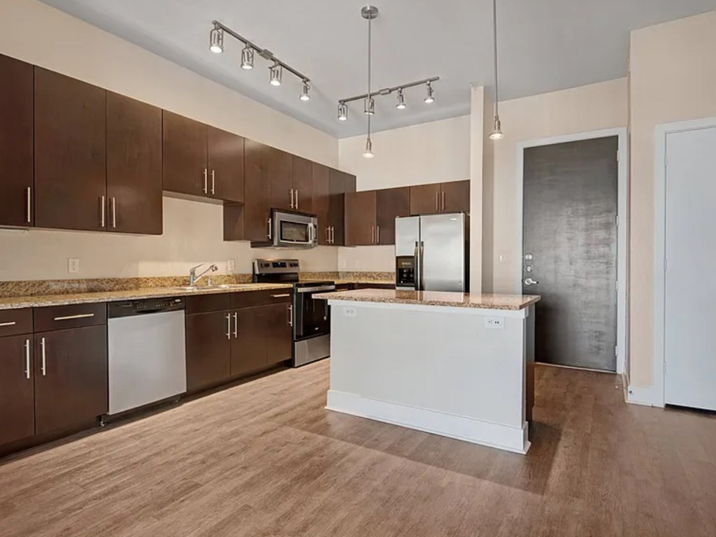 A kitchen with brown cabinets and a white island.