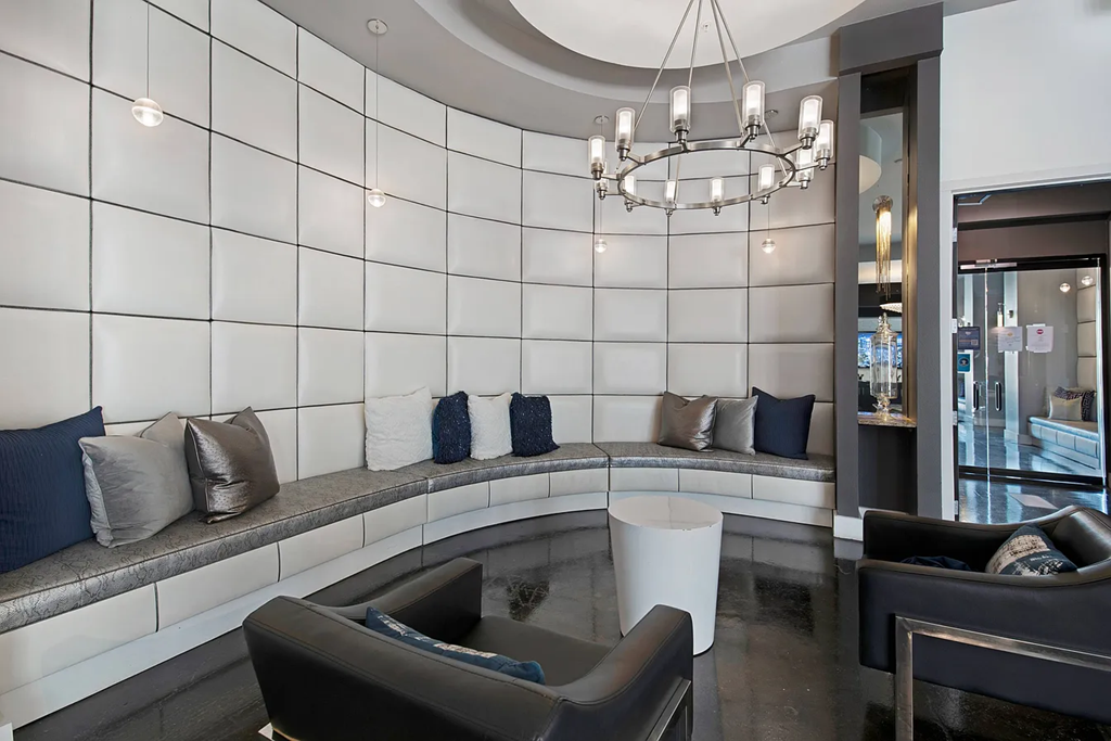 A modern living room with a curved bench and a chandelier.