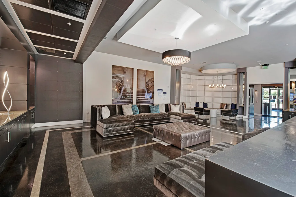 A spacious lobby with a marble floor and a large abstract painting on the wall.