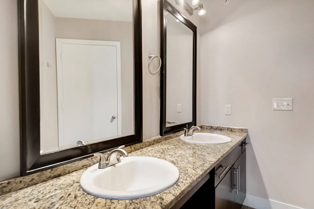 A bathroom with a sink and mirrors.