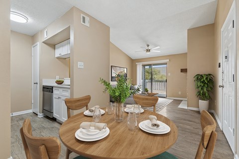 A dining room with a table set for two with a view of the backyard.