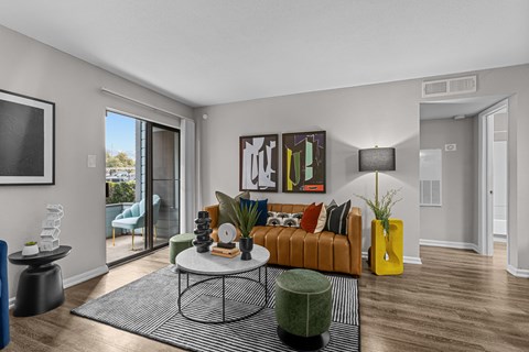A living room with a brown sofa and a painting on the wall.